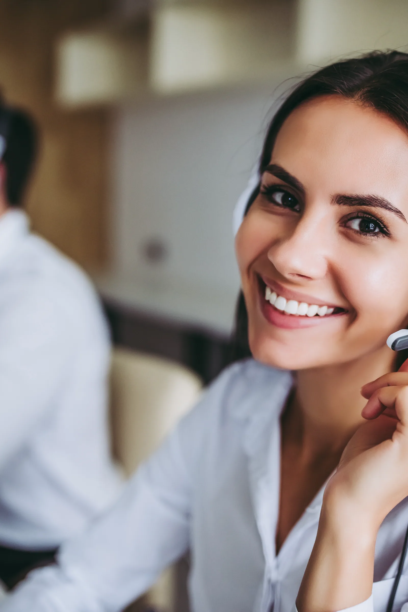 Happy Latina assistant with headset and laptop from her home office
